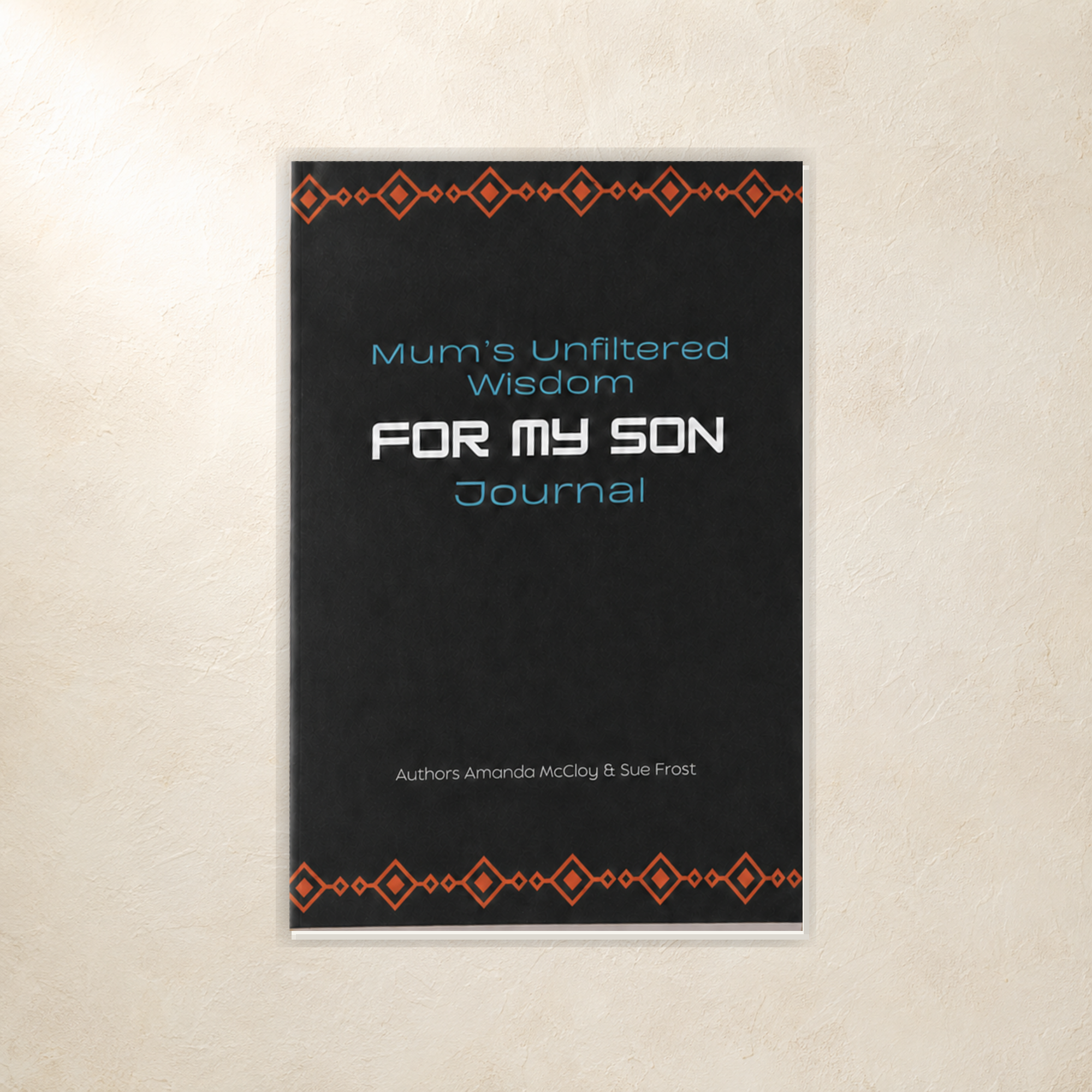 A vertical journal cover shown against a textured beige wall. The cover is predominantly black with orange geometric patterns at the top and bottom borders, and the title 'Mum's Unfiltered Wisdom FOR MY SON Journal' in white and light blue text.