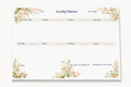 A weekly planner notepad with a white background, decorated with pastel watercolor floral designs in the corners. The top section has columns for Focus, Don't Forget, and other days of the week, with additional writing spaces below.