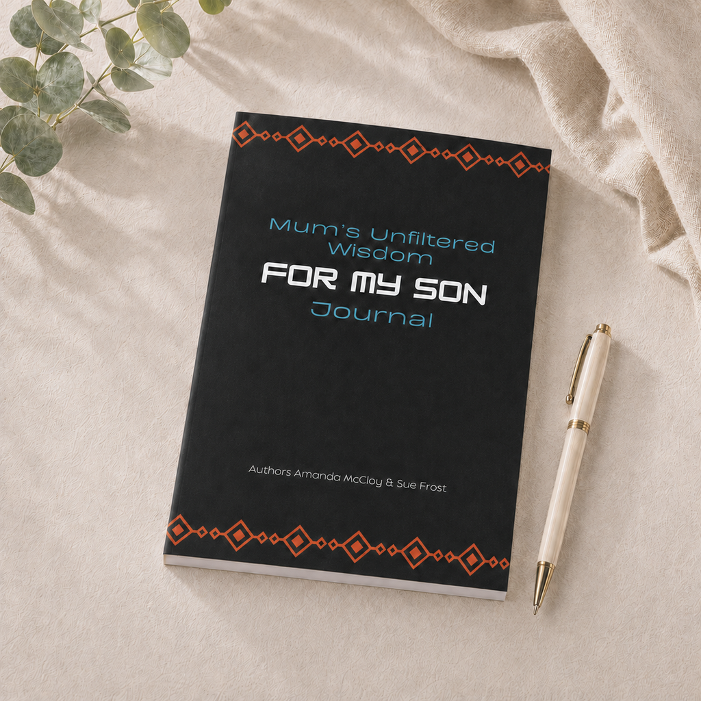 A black hardcover journal titled 'Mum's Unfiltered Wisdom FOR MY SON Journal' with orange geometric borders and light blue and white text, styled on a beige fabric surface with a cream pen and green leaves.