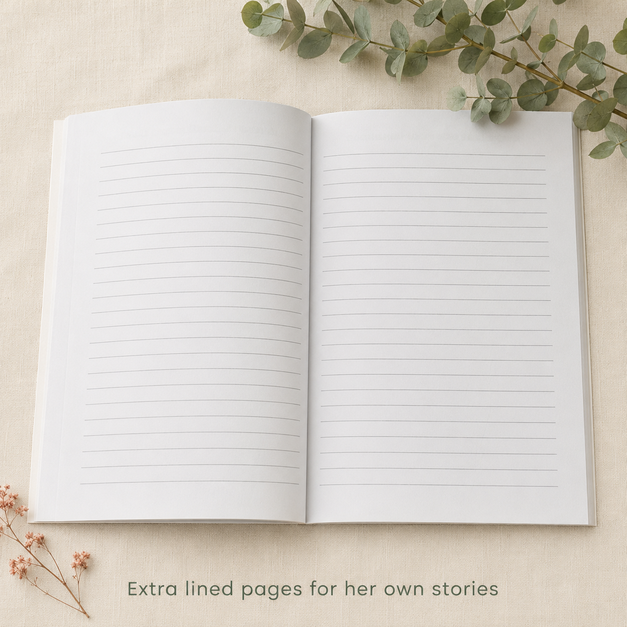 An open blank lined journal or notebook laid flat on a light beige fabric surface, with eucalyptus leaves around it and the text 'Extra lined pages for her own stories' at the bottom.